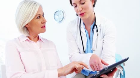 Female-doctor-and-colleague-discussing-over-digital-tablet