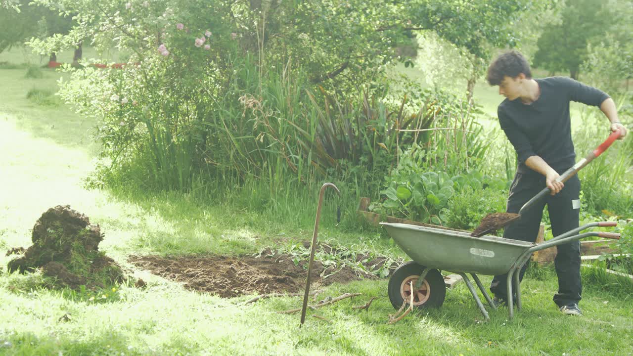 Young man gardening mixing shoveling soil