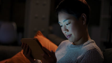 beautiful asian woman using digital tablet technology at home late night