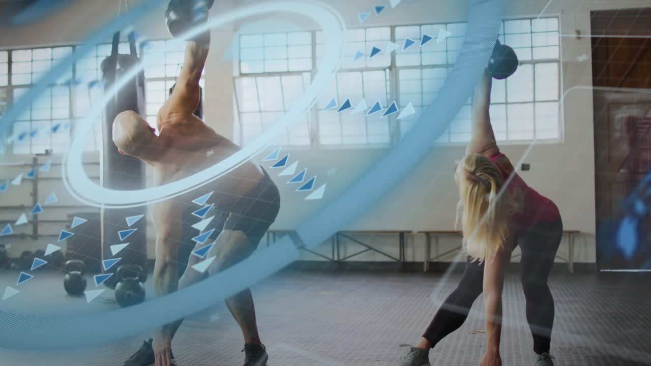 Two partners holding kettlebells overhead, hinging for core in gym, blue swirl partly covering