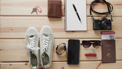 flat lay of travel items, notebook, smartphone, camera and passport on wooden background