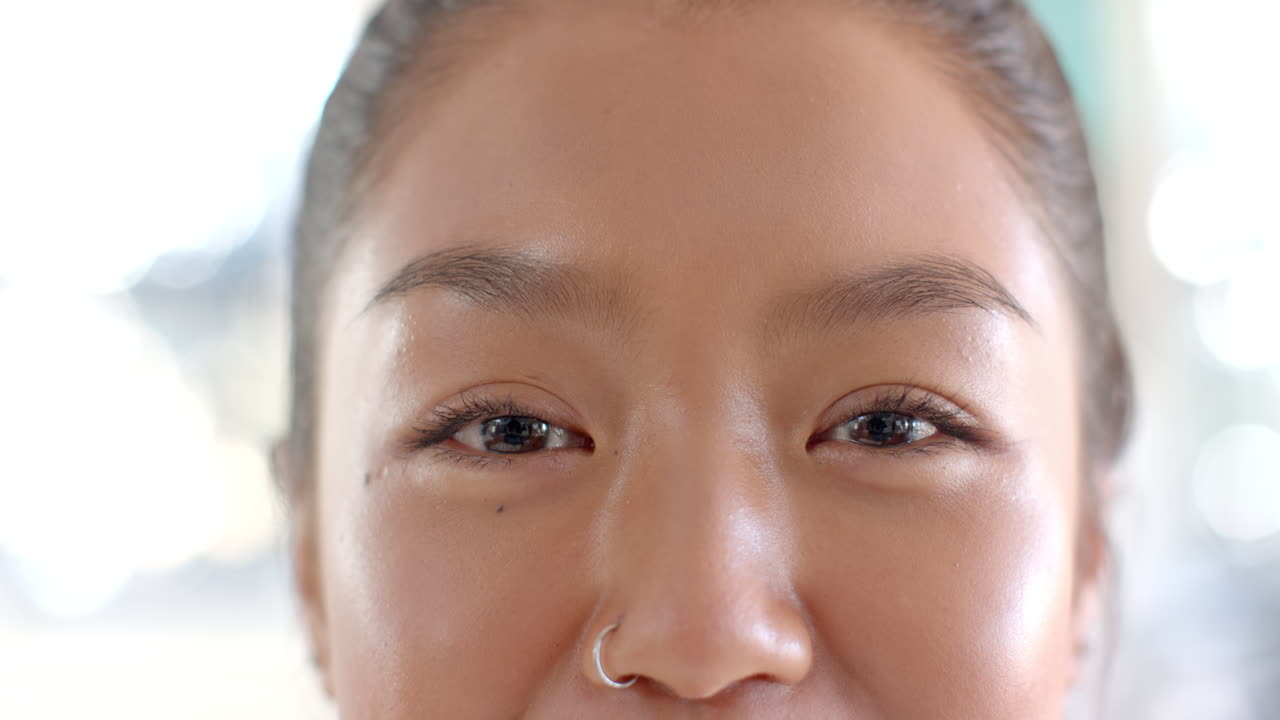 Smiling teenager with nose ring, close-up of face, happy expression