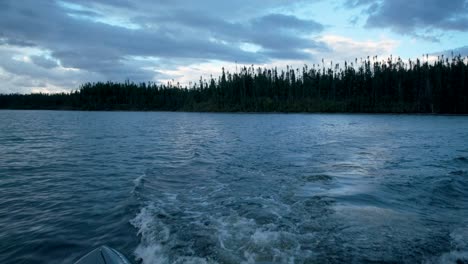 boat moving creating swirls on a lake with a beautiful and dramatic cloudy sky