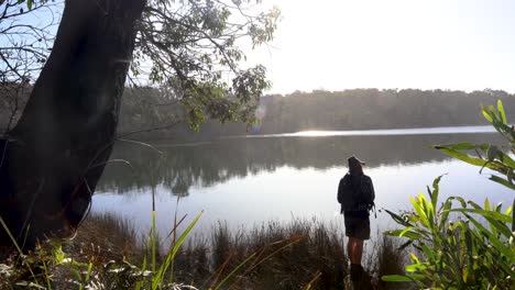 a man casts a fishing line into a calm peaceful estuary in victoria australia