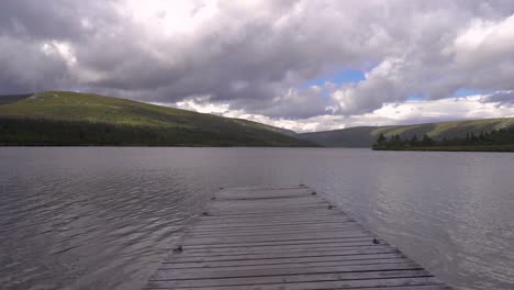 un viejo muelle que apunta a un gran lago de montaña en suecia