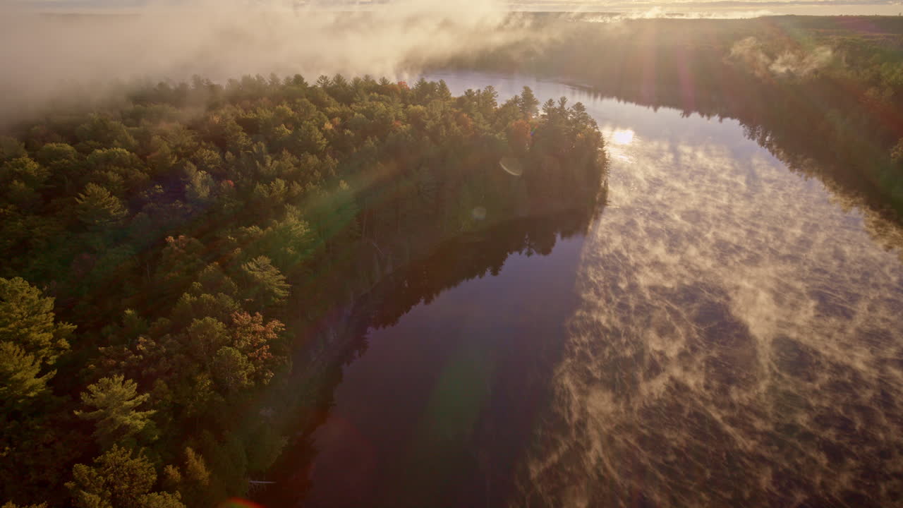 Drone captures ethereal mist lifting from water at daybreak