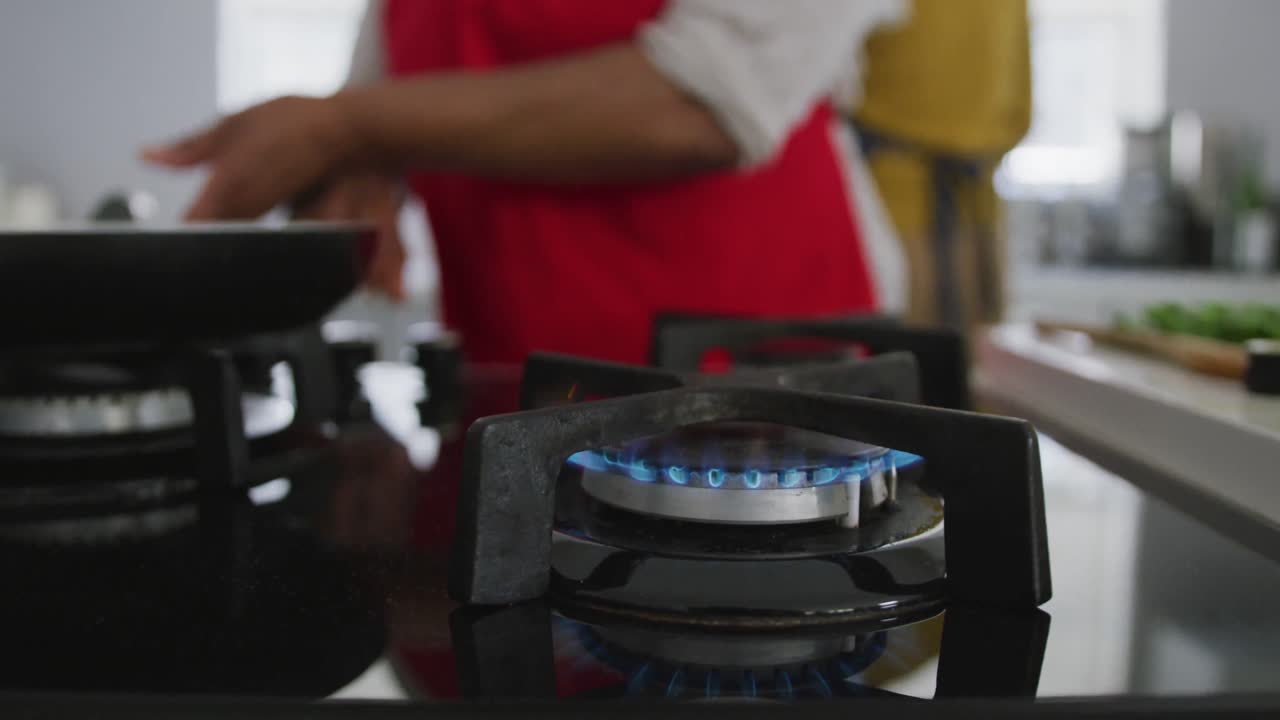 아프리카계 미국인 부부가 집에서 요리를 하고 있습니다. 격리 상태에서 사회적 거리를 두는 것