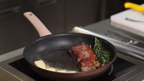 cooking a steak with butter and rosemary