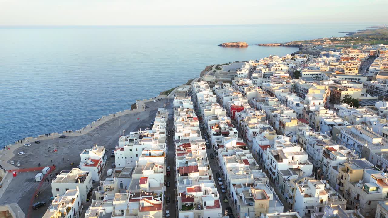 casas blancas en la ciudad italiana polignano di mare iluminadas por el sol poniente en el mar adriático en un día de verano