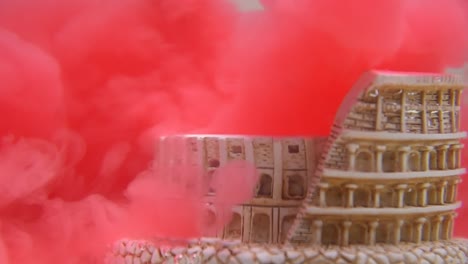 slow motion and close up of colosseum underwater with red water ink swirling around it