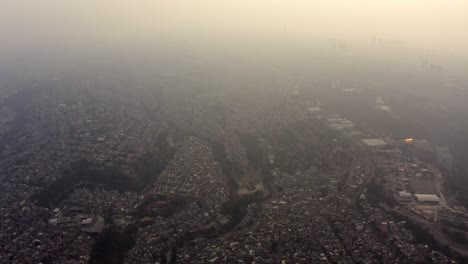 aerial shot of big urban settlements in ravines in a very polluted day in mexico city