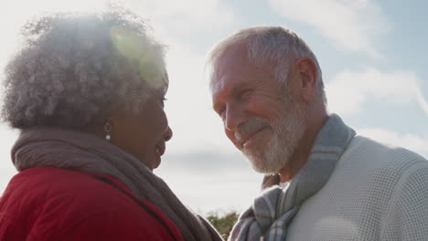 a la cabeza de una pareja de ancianos amorosos caminando al aire libre contra el sol abrasador