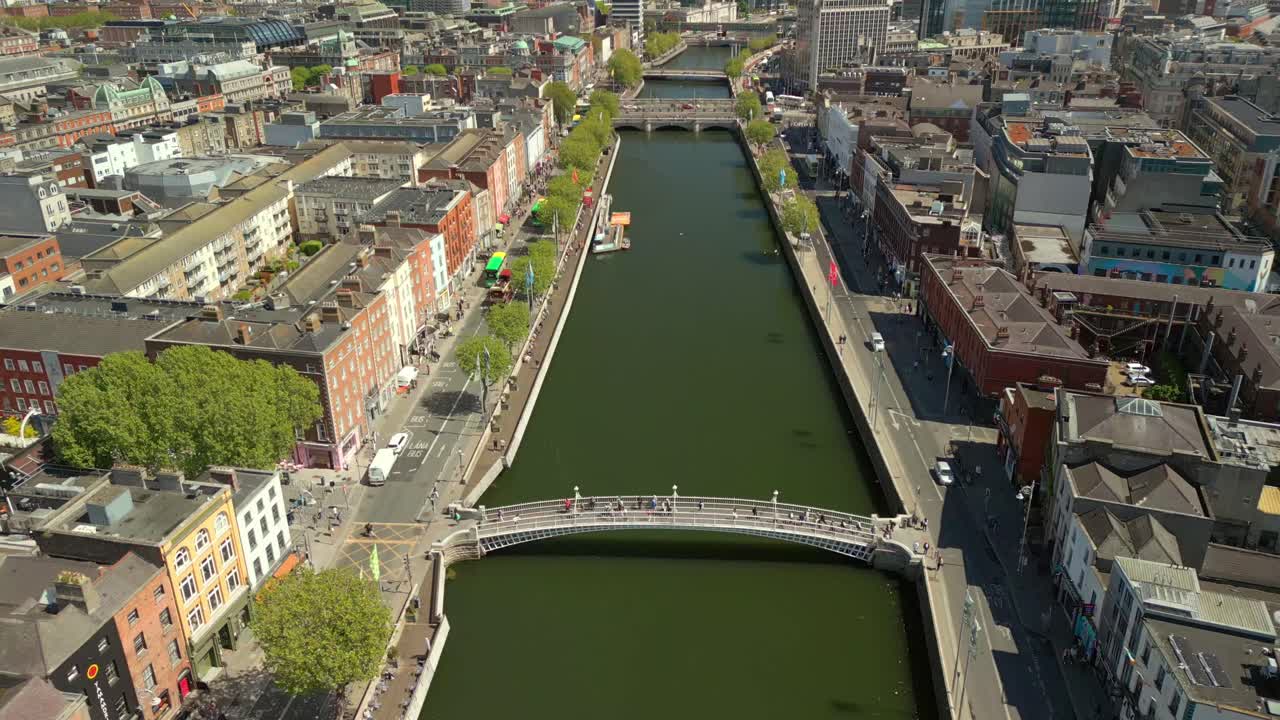 Centre-on, advancing overhead aerial video of the River Liffey, various bridges and Dublin City Centre in Dublin, Ireland on a bright and sunny day. Filmed in 4K, 60FPS and with Rec709 color.