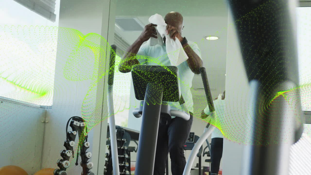 middle-aged man exercising on elliptical, displaying animated fitness chart and heart rate icon