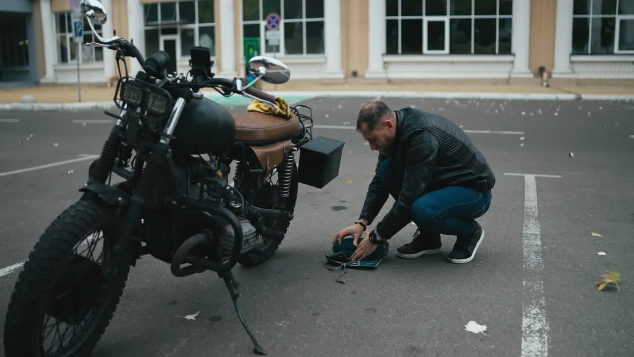 주차장 에서 오토바이 를 수리 하는 사람