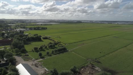 cámara lenta aérea del hermoso campo holandés durante la puesta de sol con ciudades en el fondo