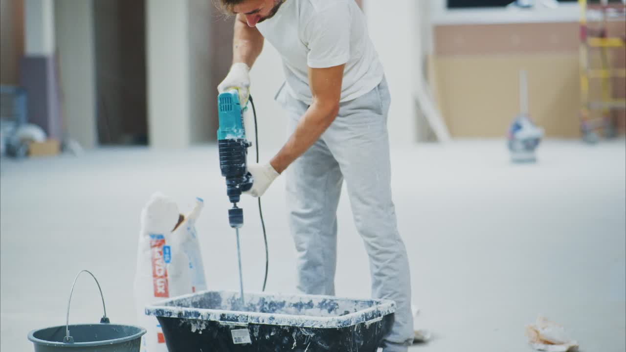 A Skilled Worker Demonstrating Precision and Focus While Operating a Power Tool in a Newly Constructed Space, Showcasing the Art of Craftsmanship and Renovation