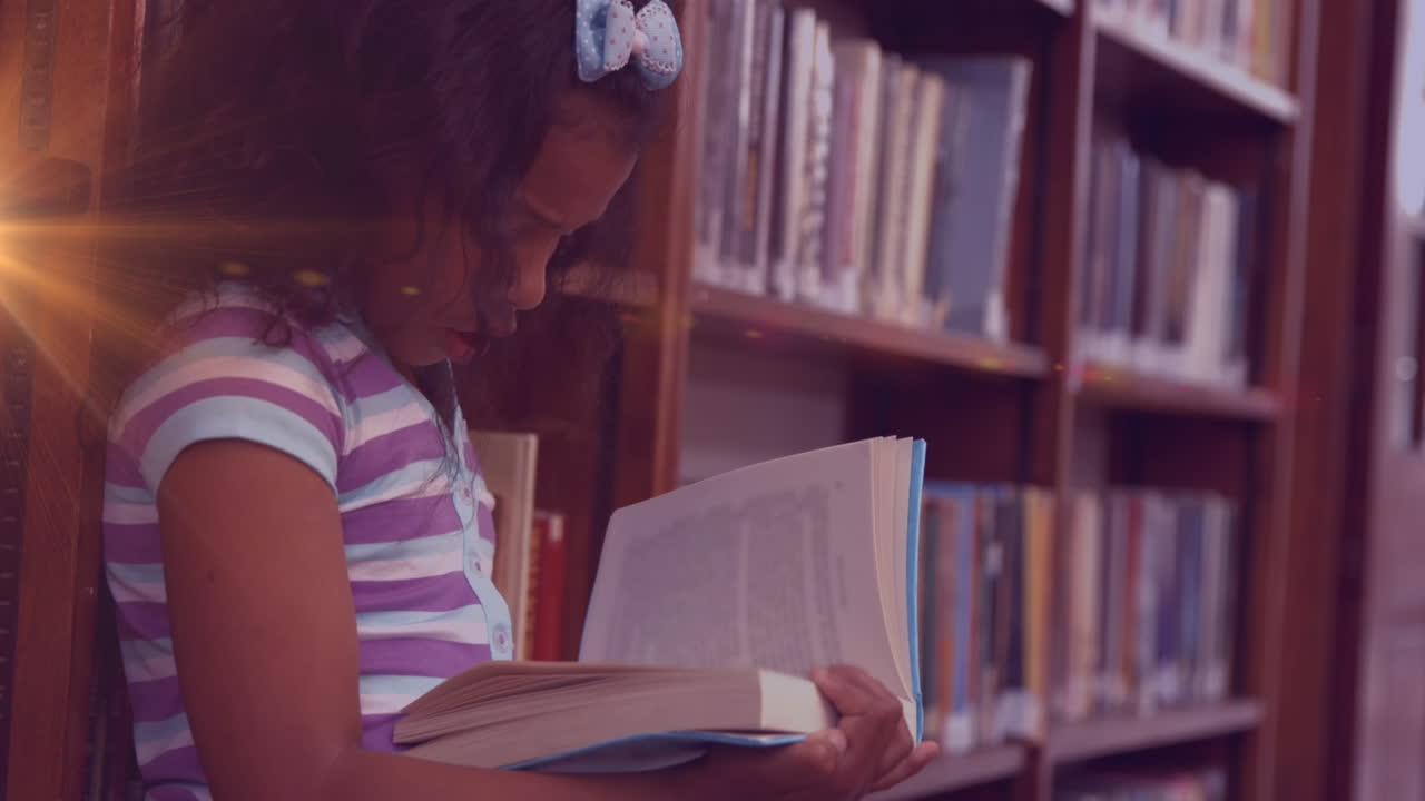 animación de senderos de luz sobre una niña biracial leyendo un libro