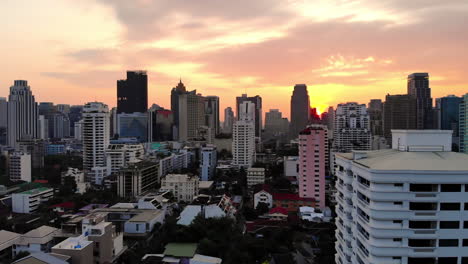 aerial pullback reveal view of bangkok's skyscrapers at sunrise