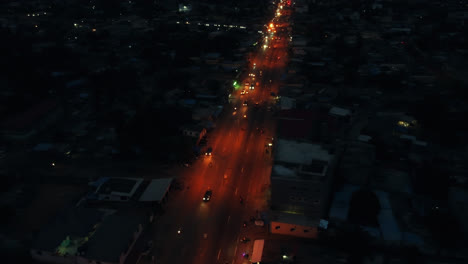 cinematic 4k travelling aerial drone shot of road traffic at night with cars driving during rush hour in african city - lomé, togo