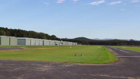 aircraft descends and lands on a grass-lined airstrip