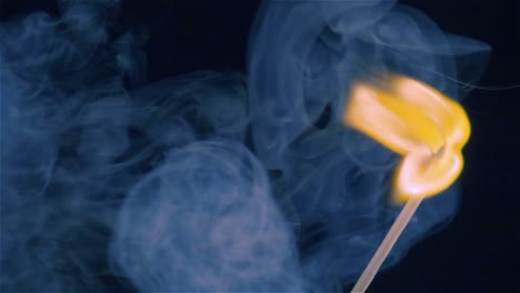 burning match on a black background in slow motion