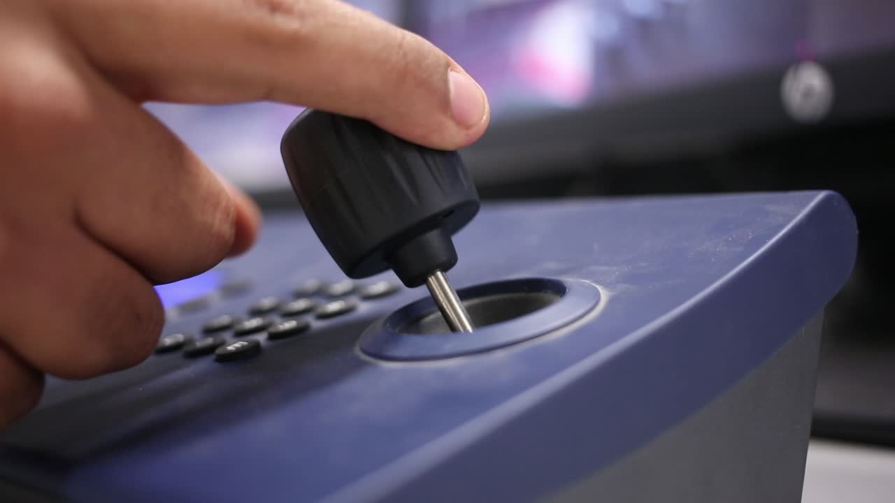 guardia de seguridad utiliza un joystick para controlar una cámara de seguridad