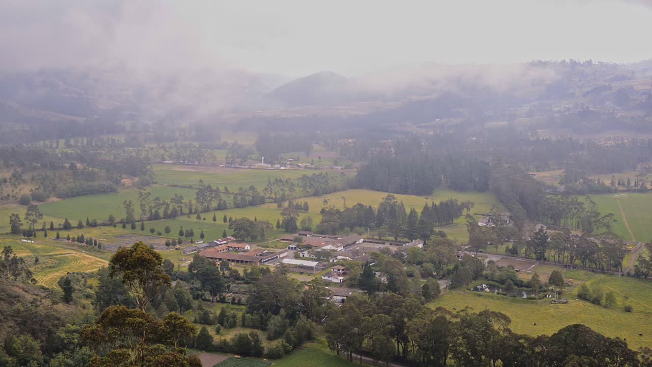 Vista del paesaggio andino, con un villaggio circondato da campi coltivati, al crepuscolo, Ecuador