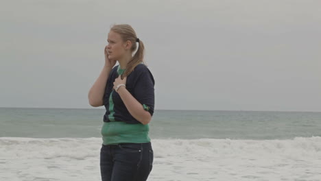 Mädchen-Mit-Telefon-Am-Strand