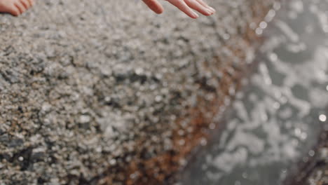 Cerrar-Mujer-Agitando-La-Mano-Sobre-El-Agua-De-Mar-En-La-Playa-Junto-Al-Mar