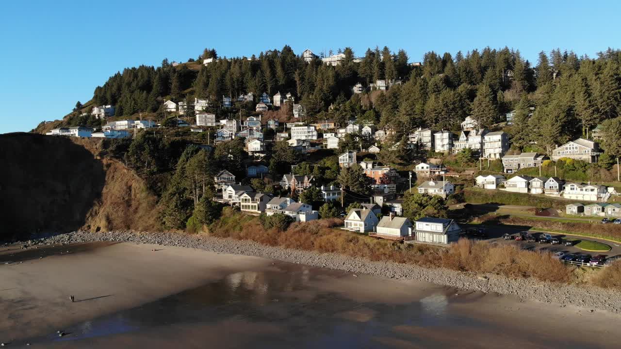 drone vuela hacia atrás lejos de un pequeño pueblo en la playa