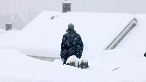 People,-with-a-dog-on-a-leash,-walk-through-heavy-snow-in-Norway