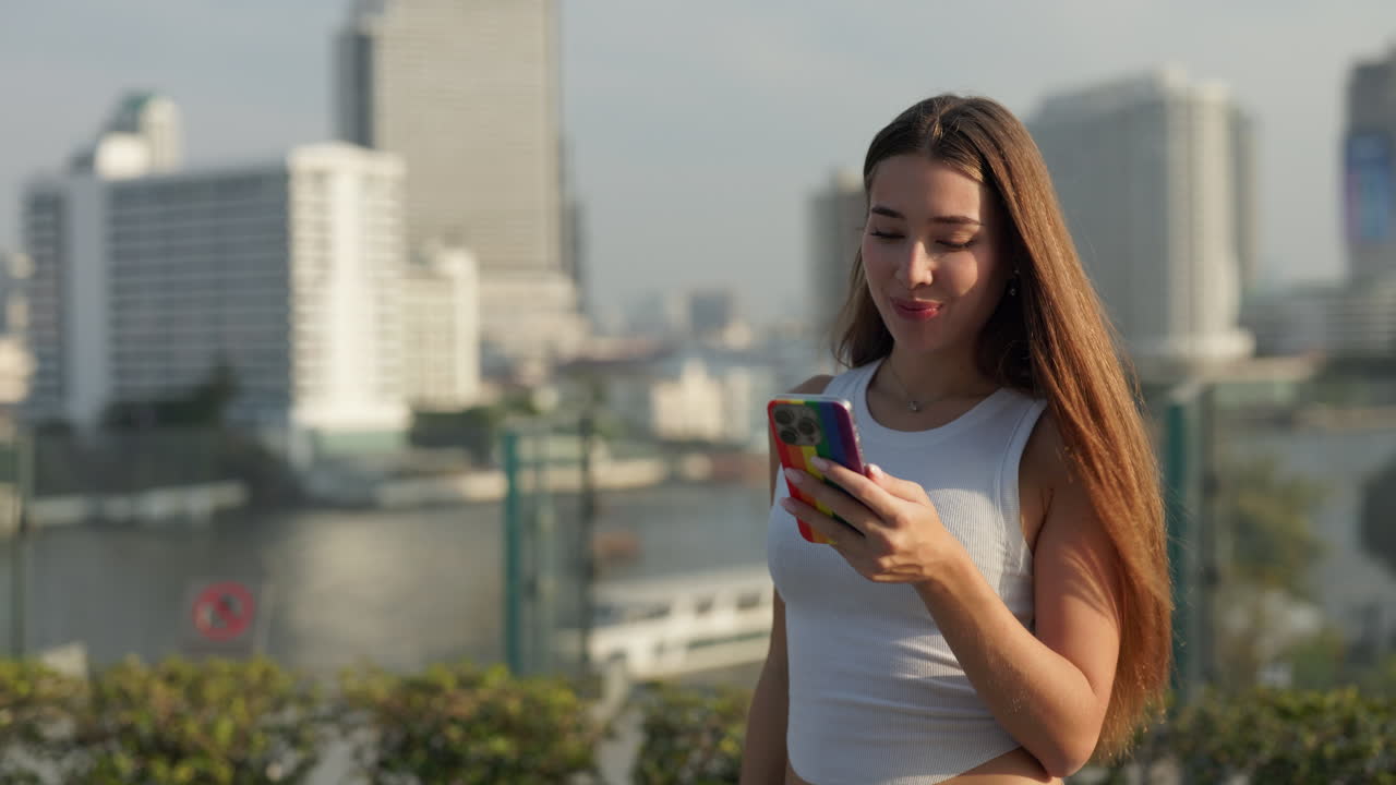 Donna che usa il cellulare con panorama urbano sullo sfondo