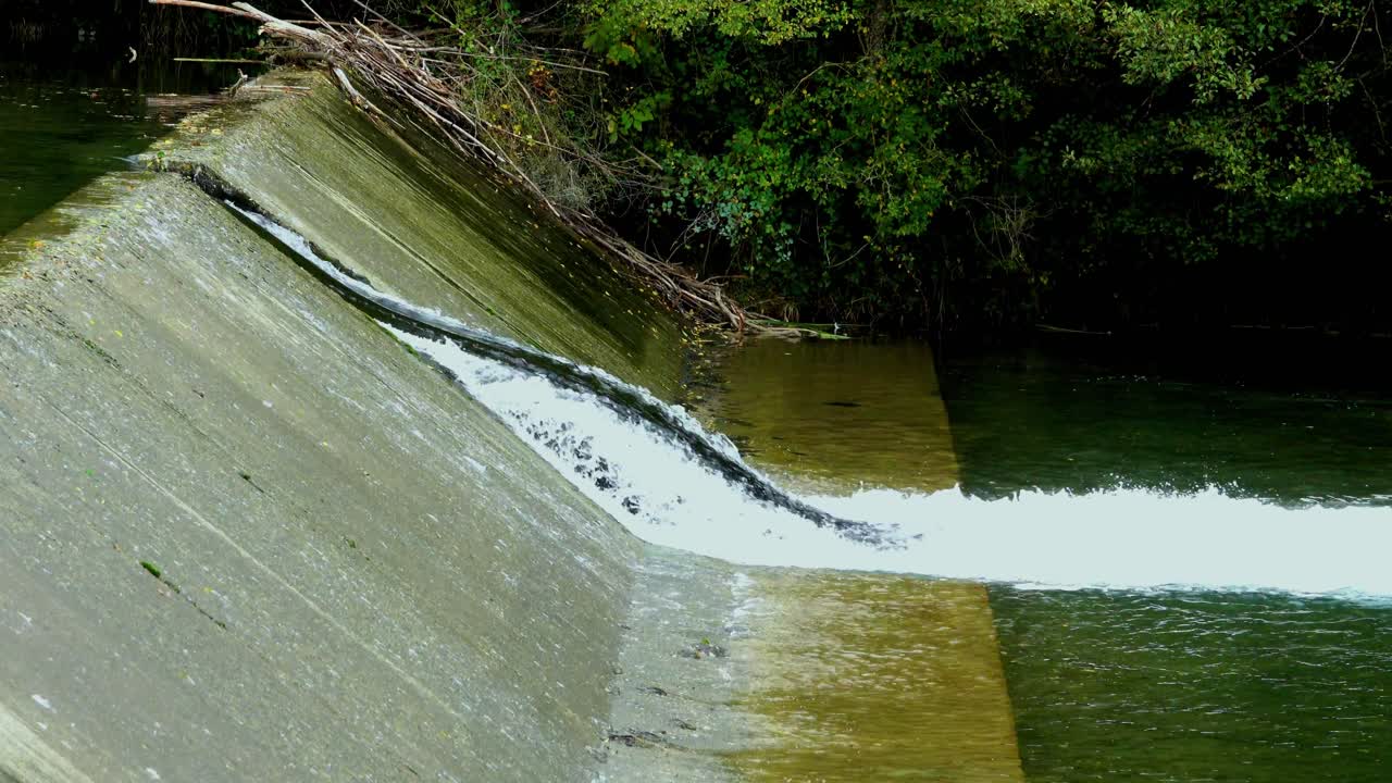 Water running over a weir with a gap for faster water for fish to travel upstream.
