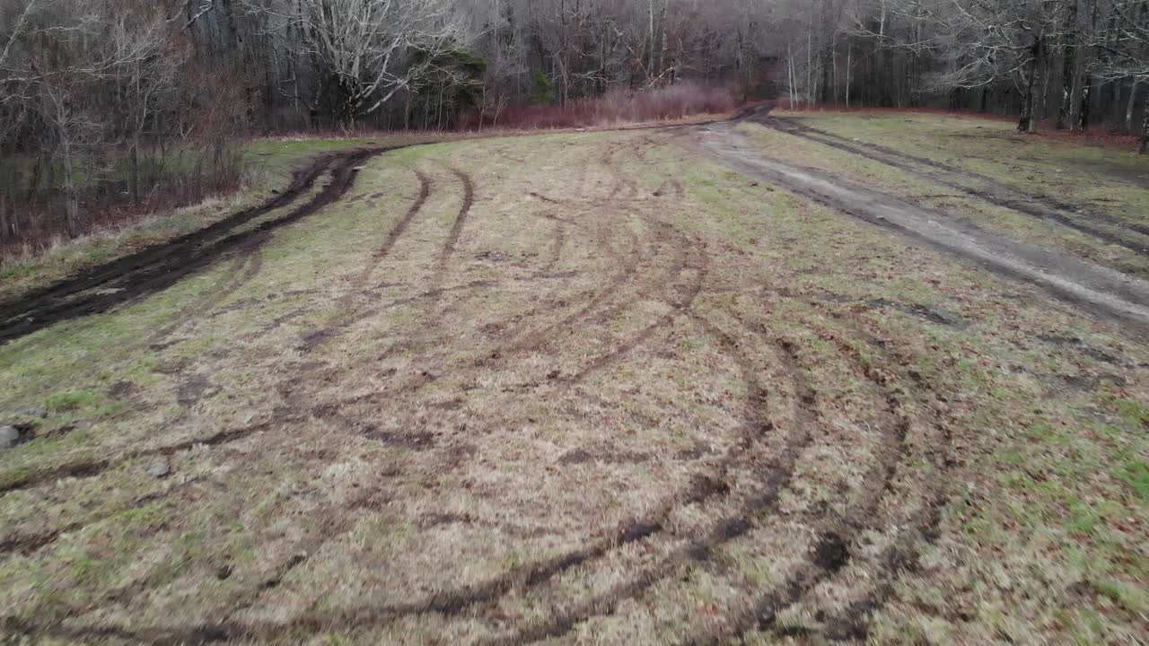 las huellas de los neumáticos en el campo de hierba destruyeron el seguimiento aéreo de drones