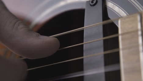 Un-Guitarrista-Experto-Toca-Una-Guitarra-Acústica-Con-Pastillas-Negras.