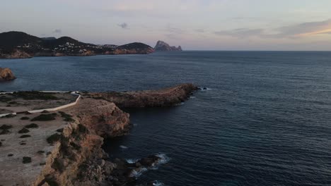 aerial tour of cliff facing the island of es vedrá in ibiza