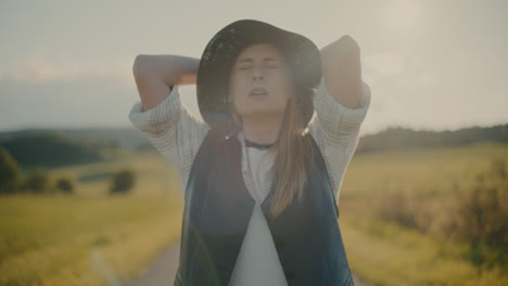 mujer joven agotada con sombrero contra el cielo