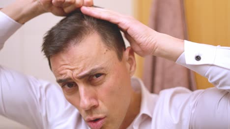 handsome man combing hair and making funny faces