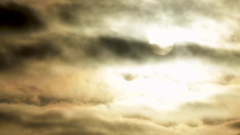 Full-Moon-or-Sun-moving-behind-beautiful-clouds-in-dark-black-sky