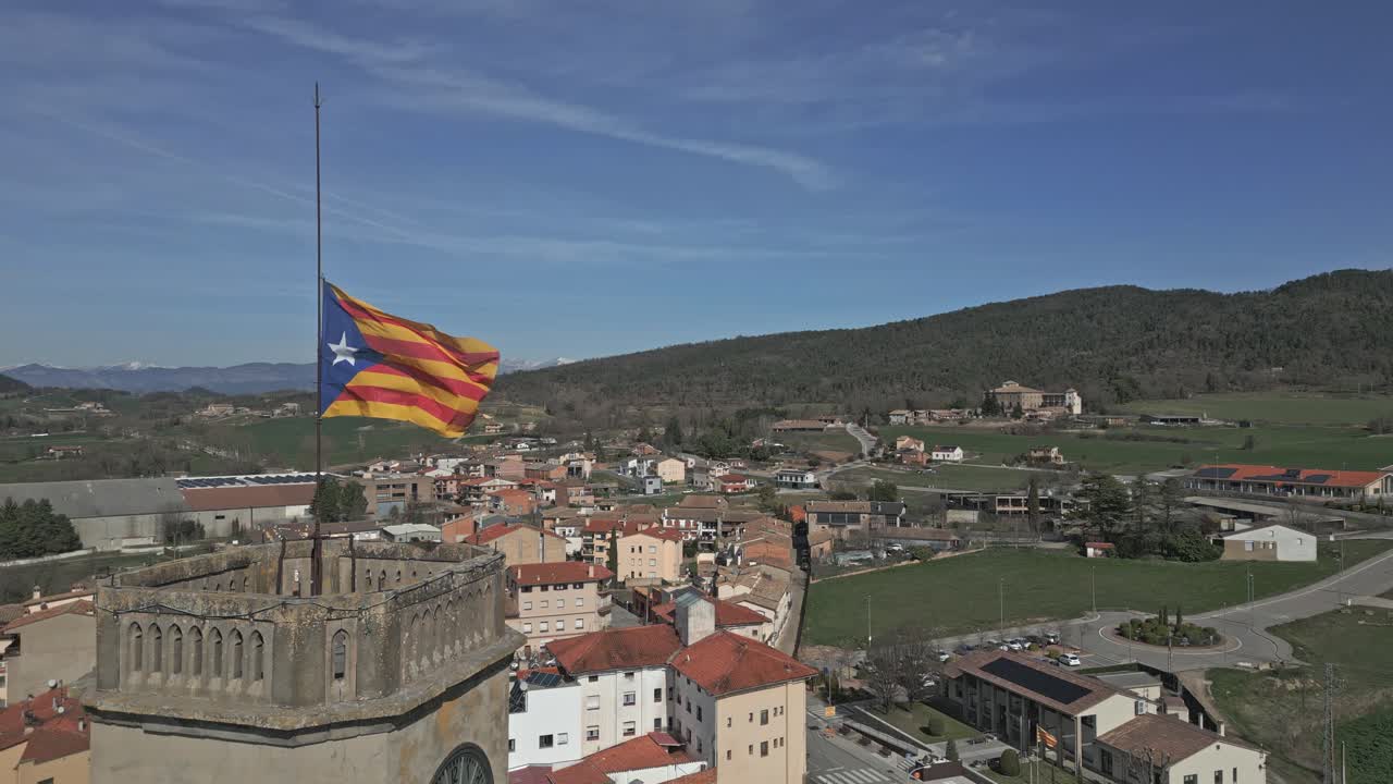 Aerial view of a Catalan Estelada flag flying above a scenic town