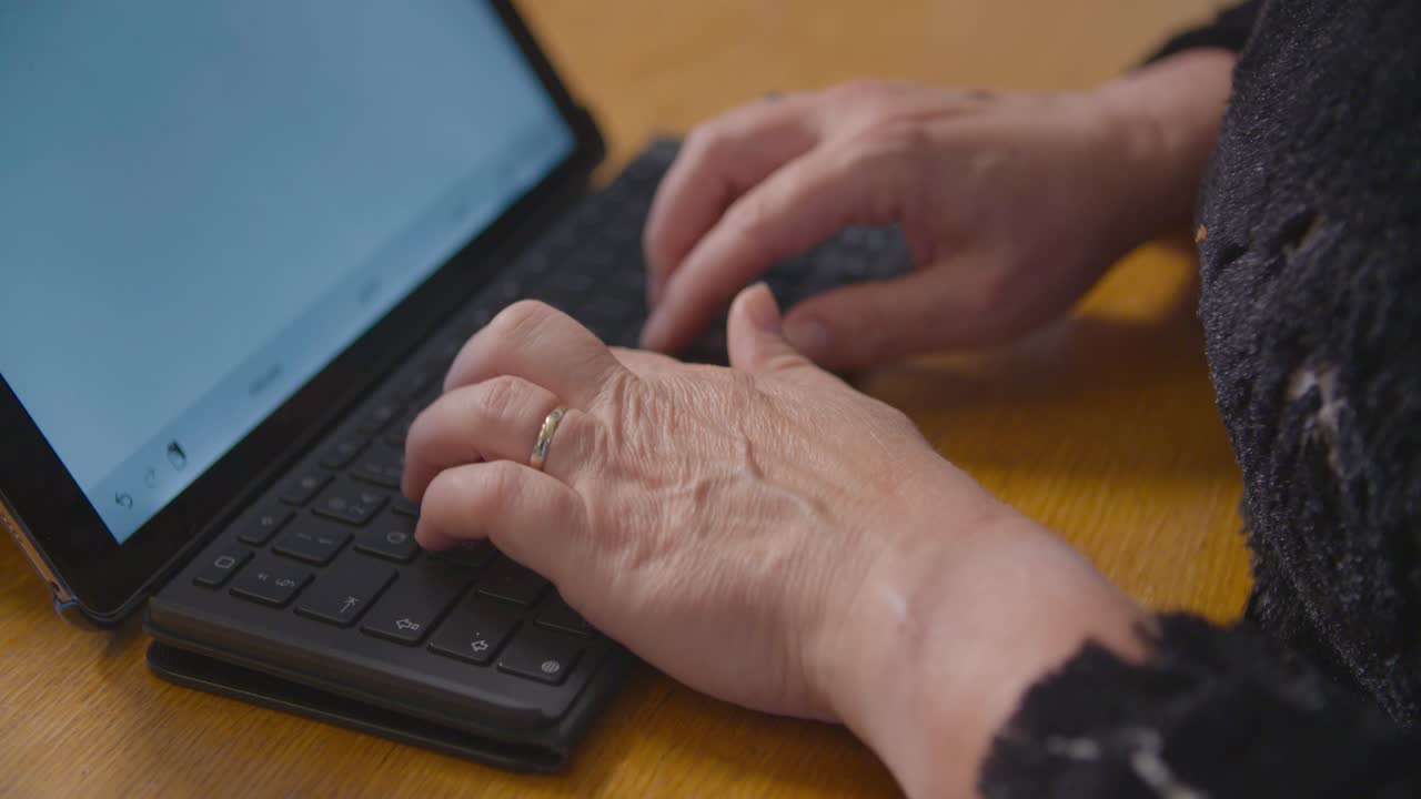 mujer escribiendo un informe en su tableta con un teclado