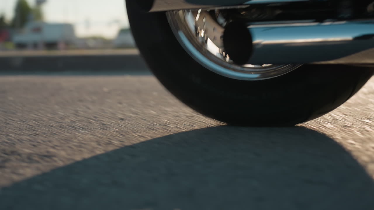 Motorcycle rider transports female passenger in leather jacket through urban street as white car passes by, showcasing freedom, movement, coordination, and lifestyle with open road