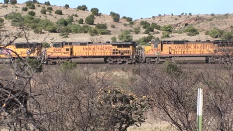 longshot of a train passing through desert pasture lands