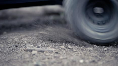 tight shot of rc car racing by from left to right in slow motion in the dirt