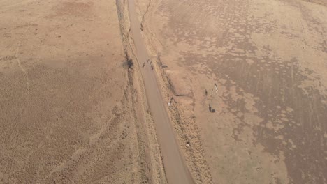 toma aérea siguiendo a un grupo de ciclistas de montaña corriendo en un camino de grava
