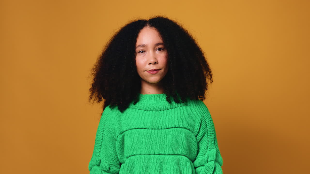 Portrait of a woman with curly hair in a green sweater