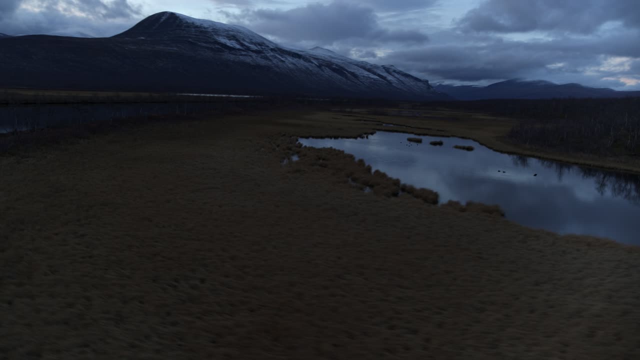 laplandia suecia pantano lago y ríos de montaña boscosos debajo de la montaña nevada en la hora azul