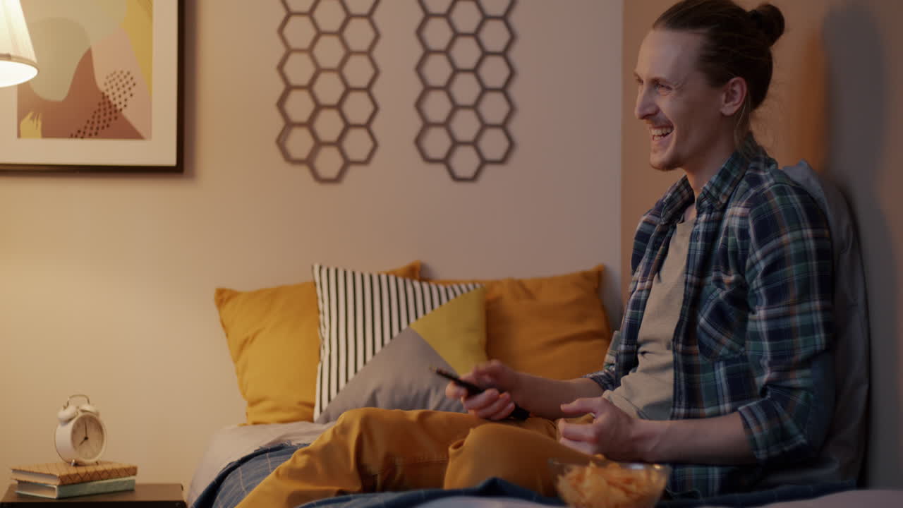 Mand ser tv i sit soveværelse