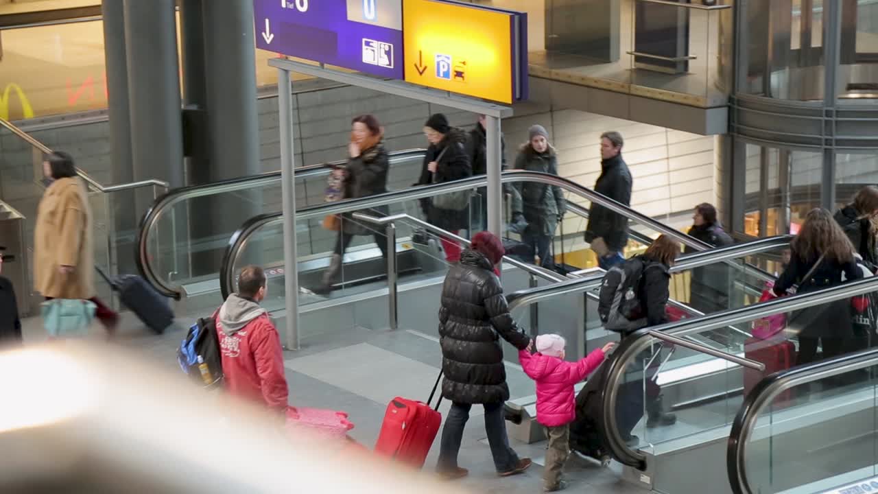 Commuters on escalators in a busy modern train station